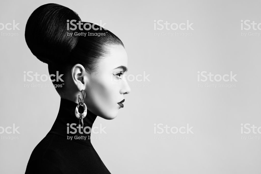 Retro style black and white fashion portrait of elegant female model with hair bun hairstyle and eyeliner makeup